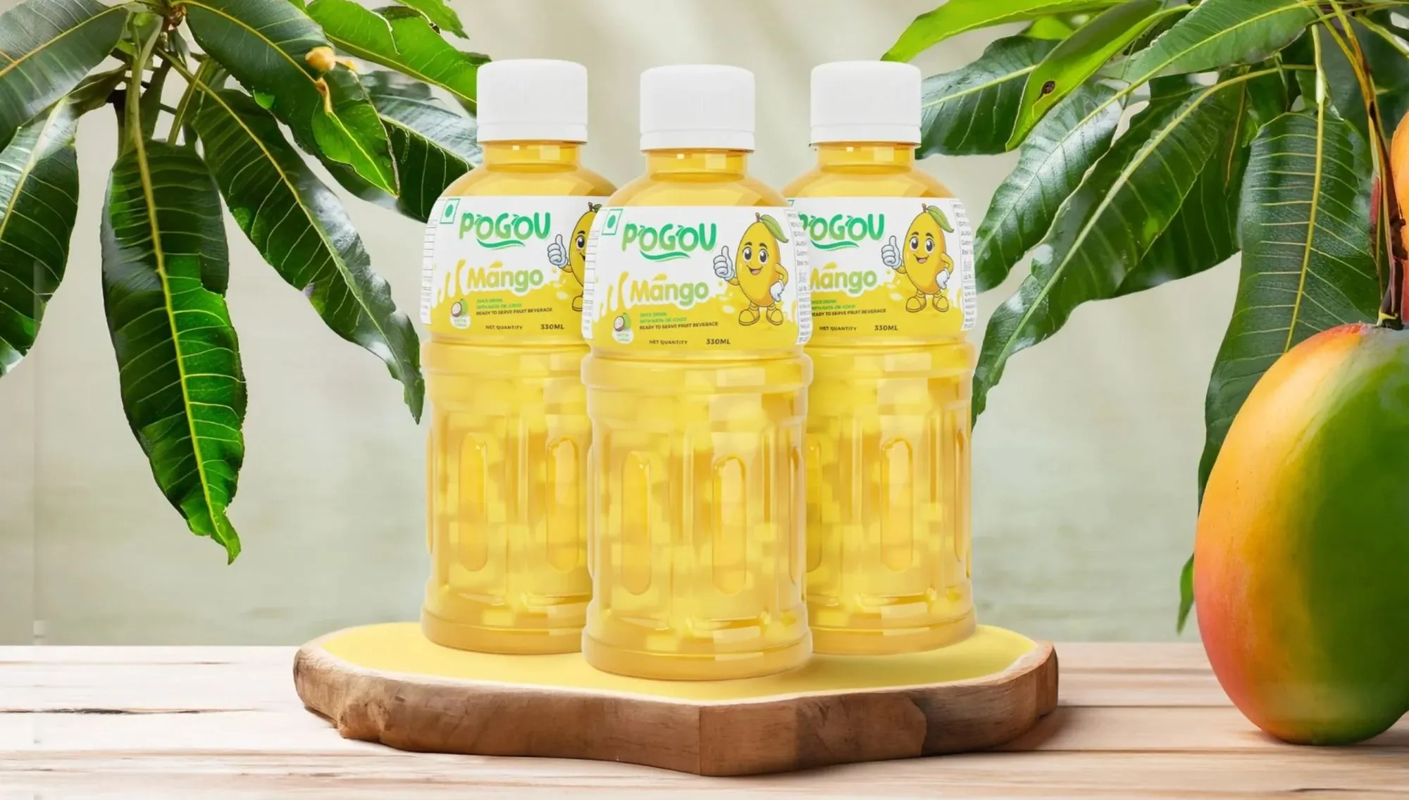 Three bottles of Pogou Mango juice on a wooden board beside a mango
